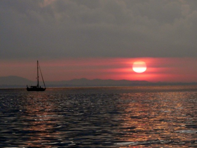 sunrise with anchored sailboat